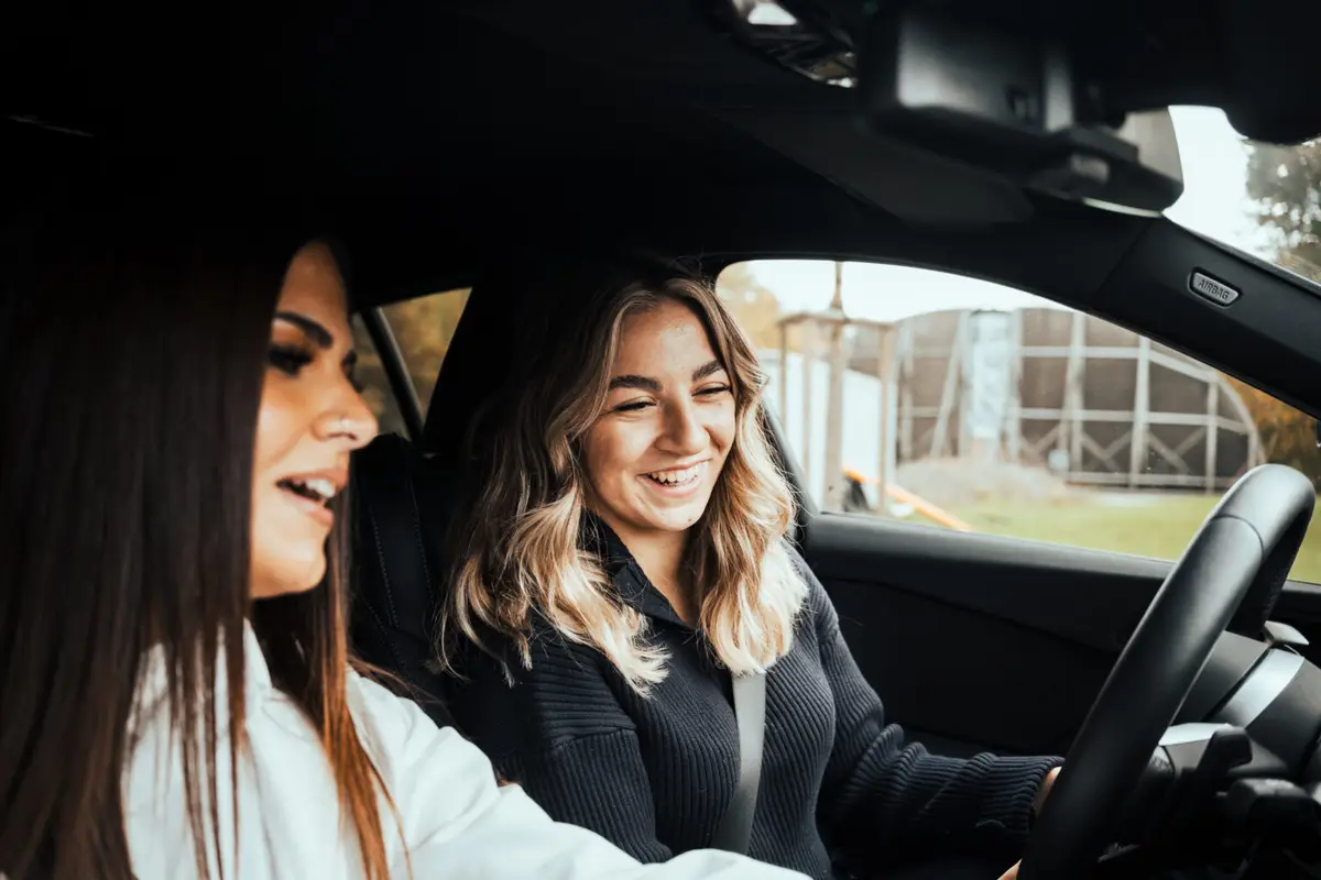 Fahrlehrerin und Fahrschülerin im Auto während einer Übungsfahrt
